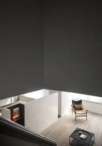 A modern minimalist living space featuring a concrete wall and a single chair.