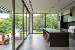 Modern minimalist kitchen with glass panels and marble countertops