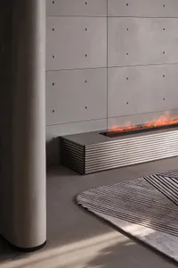 A modern fireplace featuring a concrete wall and steel accents.
