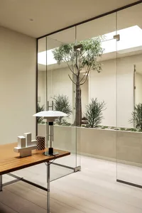 Minimalist office space featuring wooden elements and floor-to-ceiling glass wall