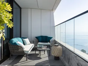 A minimalist modern balcony with metallic furniture and ocean view.