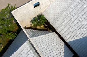 Top-down view of a modern building with a metallic roof and minimalist design.