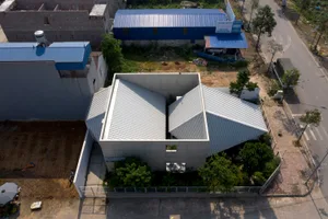 A modern house with a unique architectural design featuring concrete materials and a minimalist aesthetic.