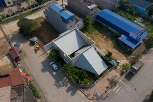 A modern house with a metal exterior, featuring a unique angular roof and minimalistic design.