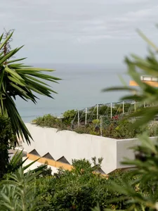Modern residential area with concrete walls and plants overlooking the ocean.