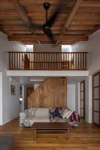 A modern living room with wooden furniture, a coffee table, and a mezzanine area.
