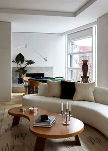 Modern minimalist residential living room with neutral colors, wood accents, and fabric furniture