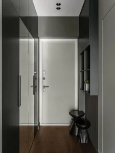 A modern entryway featuring a metal cabinet, minimalist design, and glass elements.