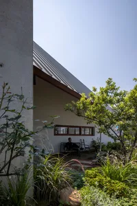 A modern residential exterior with a concrete structure and greenery.