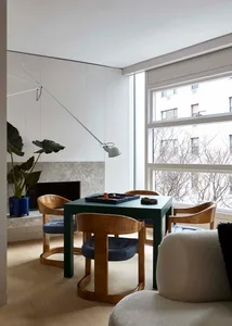 A modern living room featuring wooden furniture, marble flooring, and a comfortable seating area.