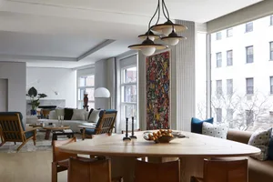 Modern living room featuring a wooden table, glass vase, and fabric seating.