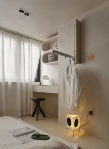 A minimalist bedroom with white furniture and a sleek, modern design.