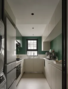A modern minimalist kitchen with white cabinets, a large window, and green accents.