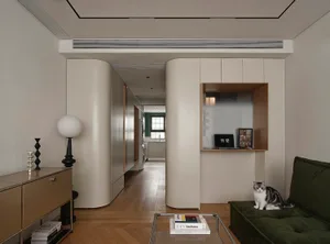 A modern white-living room with a green sofa, coffee table, and books.