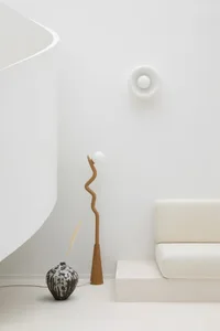 Minimalist living room featuring a modern concrete sculpture and floor lamp.