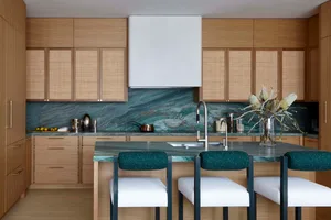 A modern residential kitchen featuring a stone countertop and white appliances.