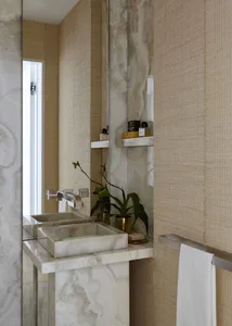 A minimalist bathroom with a marble sink and woven wallpaper.