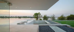 Modern minimalist residential patio featuring concrete, glass, and gravel surfaces.