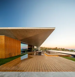 Modern architectural exterior featuring wooden and concrete elements with a sloping roof.