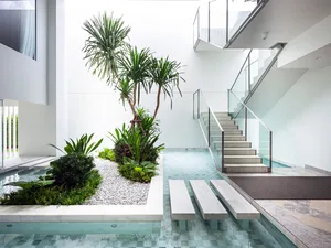 Modern staircase with glass railings and stone steps and landing