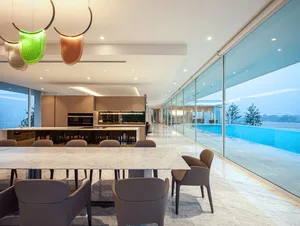 A sleek, modern kitchen and dining area featuring marble countertops and glass elements.