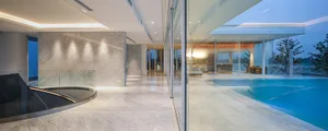 A modern residence featuring marble flooring and a large swimming pool.