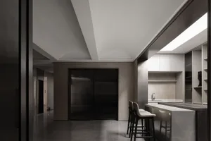 A modern minimalist kitchen with concrete finishes and sleek, dark cabinets.