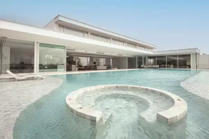 A modern residential interior featuring glass walls and concrete flooring.