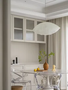 A minimalist kitchen with white marble countertops and cabinets.