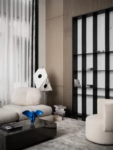 A minimalist living room featuring a textured-wood wall, a comfortable sofa, and a modern coffee table with a blue sculpture.