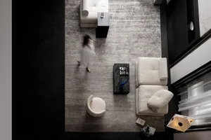 An overhead view of a modern interior design with white sofas and fabric upholstery.