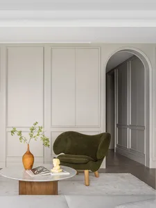 Modern living room with a green upholstered armchair, marble side table, and wooden accents.