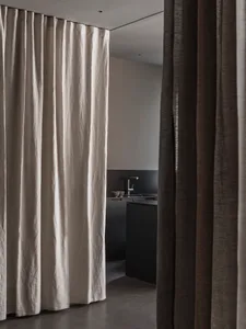 A minimalist kitchen with light-colored fabric curtains.