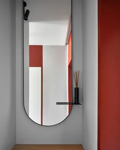 Modern entryway with a sleek, geometric mirror and a minimalist shelf.