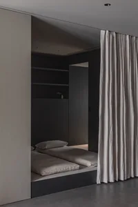A minimalist bedroom with neutral tones and a simple, modern design.
