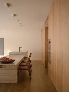 A minimalist residential kitchen featuring a marble countertop and wooden cabinets.