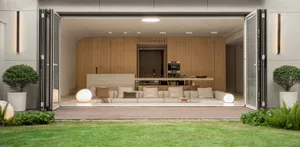 A modern living room extension featuring wooden paneling, white sofas, and large glass doors.