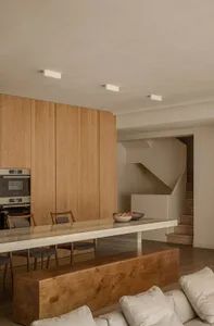 A modern residential kitchen with wooden and concrete elements.
