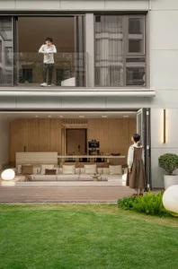 A modern residential living room with a large window and outdoor seating area.