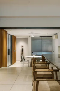 A modern dining room featuring wooden tables and chairs with elegant lighting.
