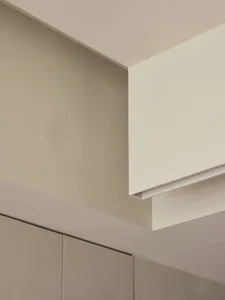 A minimalist kitchen with concrete walls and ceiling.