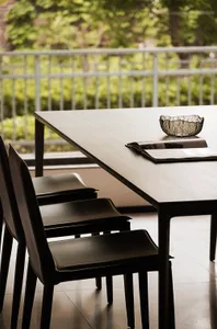 A modern dining room featuring chairs with composite materials and a table with a minimalist design.