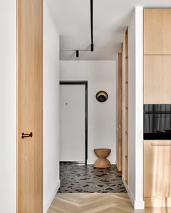 Modern kitchen featuring artistic black and white marble floor tiles with geometric patterns, wooden cabinets, and minimalist