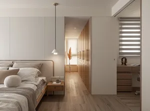 A minimalist bedroom featuring wooden cabinets and a wooden bed frame, with a hanging pendant light and a small desk area in 