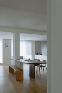 A minimalist dining room featuring a wooden table and chairs.