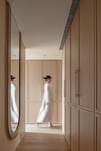 A minimalist interior design space with neutral tones and integrated storage solutions.