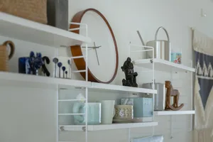 Shelves adorned with ceramic and metal decorative items in a minimalist style.