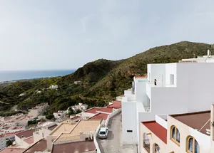 Modern architectural design featuring concrete buildings and a scenic mountain backdrop.