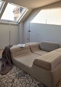 A modern loft living room featuring a white sectional sofa with a fabric upholstery arranged in a floor plan.