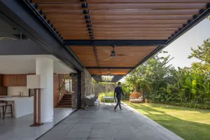 A modern residential exterior featuring stone, concrete, and glass materials.